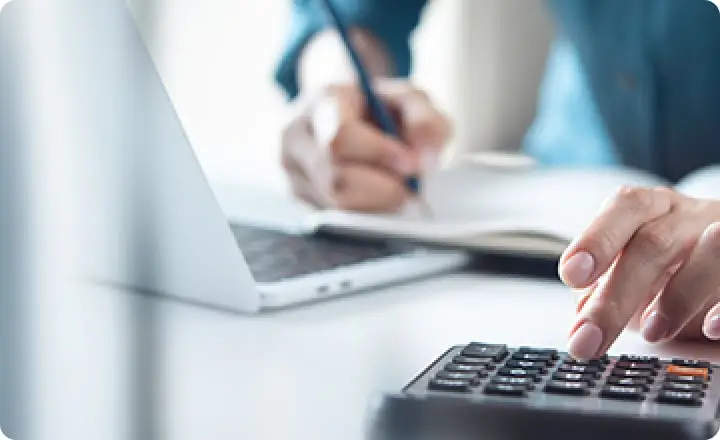 PCで調べながら電卓で計算している様子